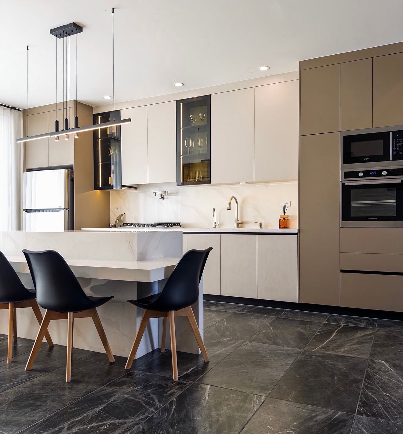 Cocina Corderosa en tonos beige con isla y vitrinas iluminadas
